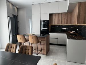 a kitchen with white cabinets and a black counter top at Marsaxlokk Penthouse in Marsaxlokk