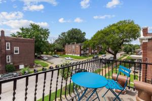 a balcony with two chairs and a blue table at Red Brick Hideaway in Soulard
