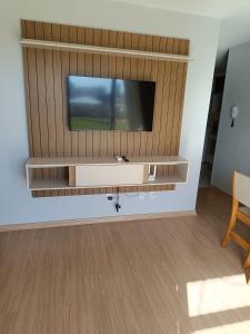 a living room with a flat screen tv on a wall at Apartamento Umuharama in Pelotas