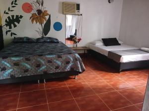 a bedroom with two beds in a room with a tile floor at hosteria y camping piedras verdes in Sopetrán