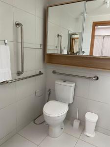 bagno con servizi igienici e specchio di Flat makia 123 C acessivel a Ipojuca