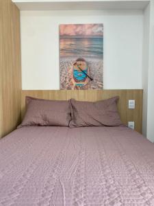 una camera da letto con un letto e un dipinto sul muro di Flat makia 123 C acessivel a Ipojuca