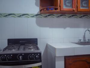 un four à plaques de cuisson dans une cuisine avec un évier dans l'établissement Lovely and close to airport, sea, and old town, à Carthagène des Indes