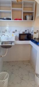 a kitchen counter with a microwave and a sink at EsMash Homes Air,bnb Lanet Nakuru in Nakuru +18 photos