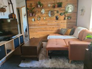 a living room with a couch and a flat screen tv at Maison avec Jardin en bord de rivière in Fresnay-sur-Sarthe