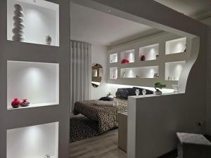 a living room with white shelves and a bed in it at LaBrafa in Comiso