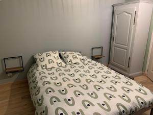 een slaapkamer met een bed met een wit en groen dekbed bij Lappart in Juvigny-en-Perthois