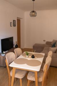 Una sala de estar con una mesa y sillas y un sofá. en Radeshi House, en Berat 25 fotos más