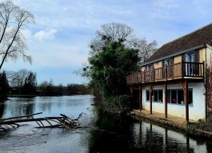 a house with a balcony next to a river at Maison avec Jardin en bord de rivière in Fresnay-sur-Sarthe