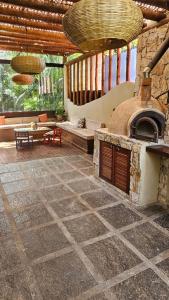 a large living room with a large stone fireplace at Casa Cacau - Guest house a 700m metros de geriba in Armacao dos Buzios