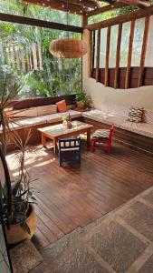 a screened in porch with a table and a couch at Casa Cacau - Guest house a 700m metros de geriba in Armacao dos Buzios