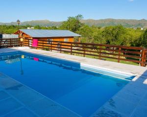 a swimming pool in front of a cabin at CABAÑAS La Perla in Bialet Massé