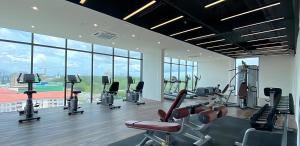 a gym with cardio equipment in a building with windows at Kozi Square, Kozi 8 in Kuching