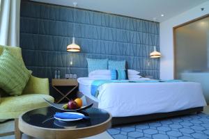 a hotel room with a bed and a table with a bowl of fruit at The Park Visakhapatnam in Visakhapatnam