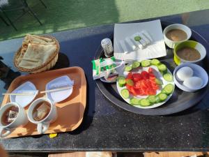 a table with a tray of food and a plate of fruit at Hostalio Pyramid View in Cairo +38 photos