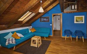 a blue living room with a blue couch and chairs at Casa Pirineos ambos apartamentos in Ulle