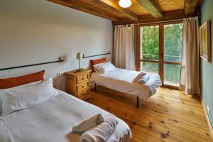 a bedroom with two beds and a large window at Casa Pirineos ambos apartamentos in Ulle