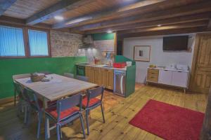a kitchen with a large wooden table and chairs at Casa Pirineos ambos apartamentos in Ulle