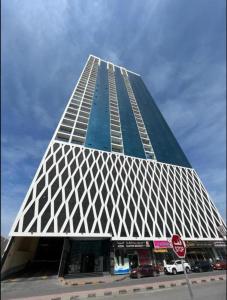 a tall building with a blue and white facade at Oasis tower family apartment 2302 in Ajman 