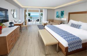 a hotel room with a large bed and a bathroom at Oceans at Carina Bay - Adults Only in Christiansted