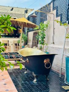 a bath tub sitting on a patio with an umbrella at Riad Dar Najwa in Marrakesh
