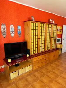 Una sala de estar con un televisor de pantalla plana en una pared. en Rose's House, en Costa da Caparica