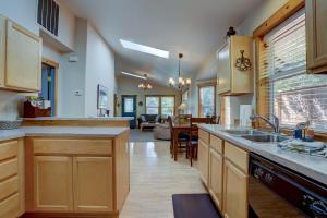 a kitchen with wooden cabinets and a living room at Huckleberry Cottage in Bend +20 photos