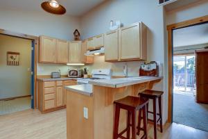 a kitchen with wooden cabinets and a counter with stools at Huckleberry Cottage in Bend