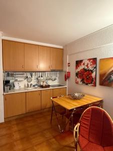 a kitchen with wooden cabinets and a wooden table at Rose's House in Costa da Caparica