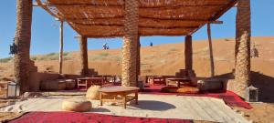 a room with tables and chairs in the desert at Erg Chigaga Regency Camp in El Gouera