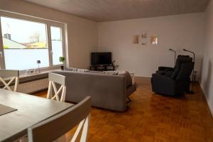 a bedroom with a bed and a chair and a television at Ferienwohnung Hygge und Mee-h-r in Brunsbüttel