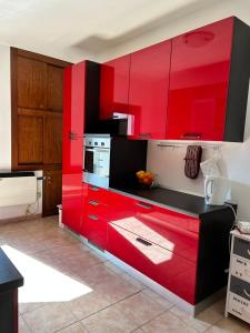 a red kitchen with red cabinets in a room at Residence Antea in Lorica