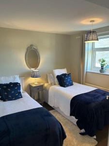 Un dormitorio con dos camas y un espejo en la pared. en Peak District - 2 Beds - Sleeps 4 - Pet Friendly, en Chesterfield