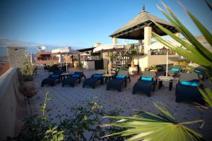 an outdoor patio with chairs and tables and umbrellas at Riad Dar Haven in Tamraght Ou Fella