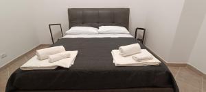 a large bed with two white towels on it at Alloggio Turistico fata in Civitavecchia