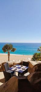un tavolo e sedie su una spiaggia con l'oceano di Grand Solmar Land's End Resort De Lujo Los Cabos a Cabo San Lucas