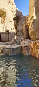 una piscina d'acqua in un canyon con cascata di Grand Solmar Land's End Resort De Lujo Los Cabos a Cabo San Lucas 1 altra foto