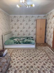 a bedroom with a bed and a cabinet in it at Apartment on Akhmetova 10 in Almaty