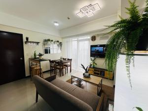 a living room with a couch and a dining room at Casa Tagpuan at Manhattan Heights in Manila