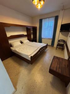 a bedroom with a large bed and a table at Parkhotel Rottweil in Rottweil