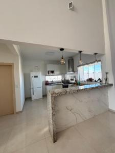 une grande cuisine avec un grand comptoir en marbre dans l'établissement Casa da Mãe São Pedro, à São Pedro da Aldeia