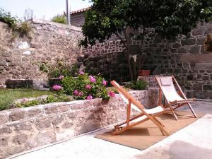 a chair sitting next to a stone wall with flowers at Molivos Tower in Mithymna