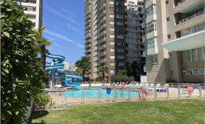 a swimming pool with a water slide in a city at Apartamento Viña del Mar 1270 in Viña del Mar