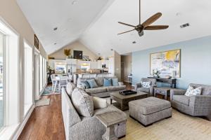 a living room with couches and a ceiling fan at Seaside Sunrise Luxury Beachfront, Hot Tub, Firepit, Elevator in Port Bolivar