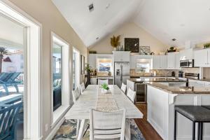 a kitchen with white cabinets and a table and chairs at Seaside Sunrise Luxury Beachfront, Hot Tub, Firepit, Elevator in Port Bolivar