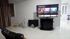 a living room with a flat screen tv on a wall at Cha-am Beach Vacation Home in Cha Am