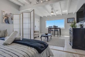 a bedroom with a bed and a tv and a table at 1Bd Ocean Waves Surf Parking in San Diego
