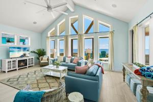 a living room with blue walls and large windows at Wayward Sun Luxury 4BR Gulf Retreat w Pool, Hot Tub & Elevator in Port Bolivar