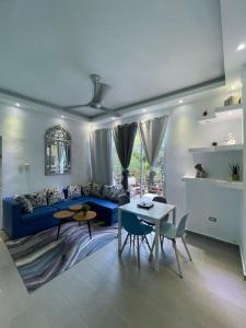 a living room with a blue couch and a table at VILLAS SONJASAA LOFt in Baní