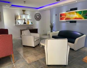 a waiting room with white furniture and a purple ceiling at VILLAS SONJASAA LOFt in Baní